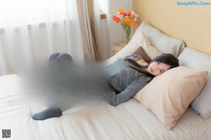A woman sitting on a blue couch with her legs crossed.
