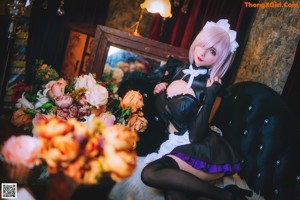 A woman sitting on a black couch in a room.