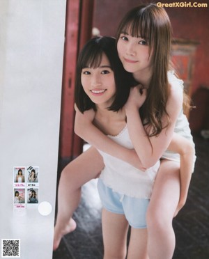 Two young women sitting in a bathtub with their feet in the water.