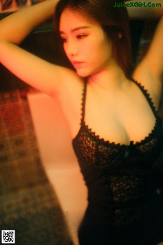 A woman in a black lingerie posing for a picture.