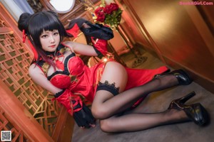 A woman in a red and black outfit smoking a cigarette.