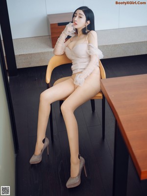 A woman sitting on a chair in a room.