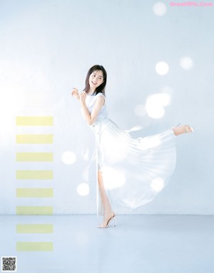 A woman in a white dress posing for a magazine.
