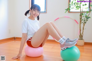 A woman in a pink bikini standing next to a pink ball.
