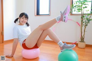 A woman is playing with a hula hoop in a room.