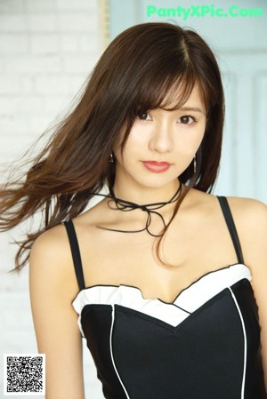 A woman in a black and white bathing suit sitting on the stairs.