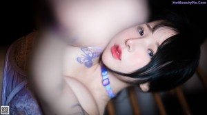 A woman in a purple lingerie holding a chain.