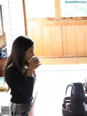 A woman sitting in a chair in front of a window.