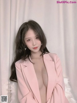 A woman in a pink suit posing for a picture.