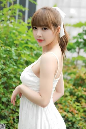 A woman in a white lingerie posing for a picture.