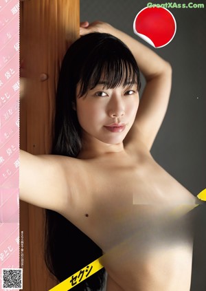 A naked woman sitting in front of a window.