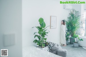 A woman sitting on the floor next to a bathtub.