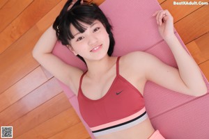 A woman is doing a yoga pose on a pink mat.