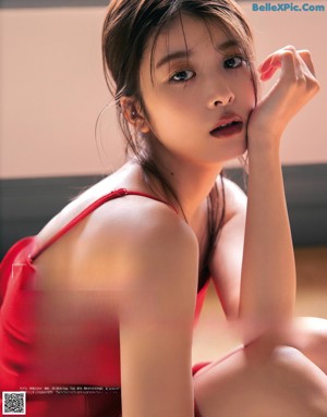 A woman in a pink jacket and black skirt posing for a magazine.