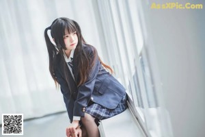 A woman in a school uniform sitting on a chair.