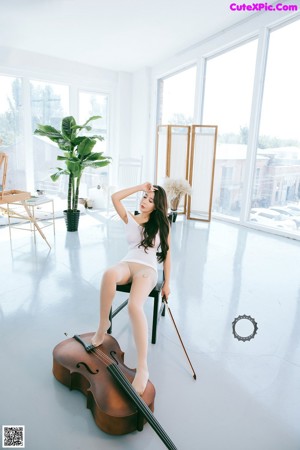 A woman sitting on a chair playing a cello.
