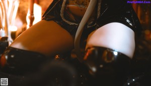 A woman in a black and white outfit sitting on a bed.