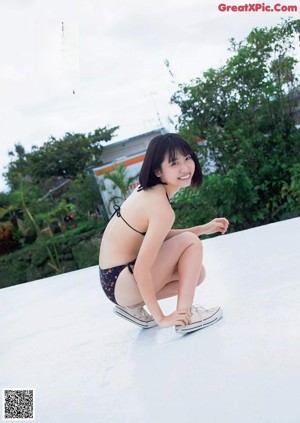A woman laying on top of a white bed.