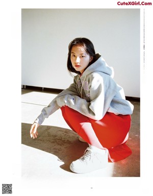 A magazine with a picture of a woman in a hoodie.