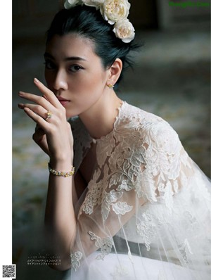 A woman in a wedding dress holding a bouquet of flowers.